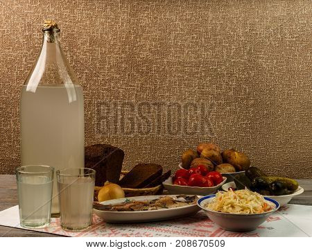Ukrainian National Drink And Snack. The Big Bottle And Glass Of Moonshine On The Old Wooden Table