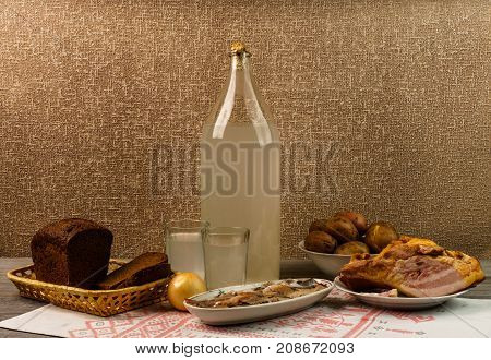 Ukrainian National Drink And Snack. The Big Bottle And Glass Of Moonshine On The Old Wooden Table
