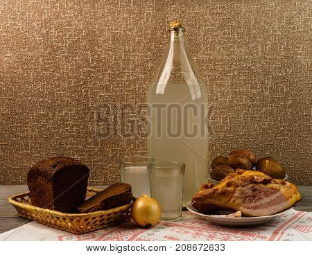 Ukrainian National Drink And Snack. The Big Bottle And Glass Of Moonshine On The Old Wooden Table