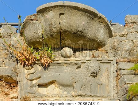 Fragment of stone wall of ruins of fortress of St. John (Illyrian fort) with image of lion Kotor Montenegro