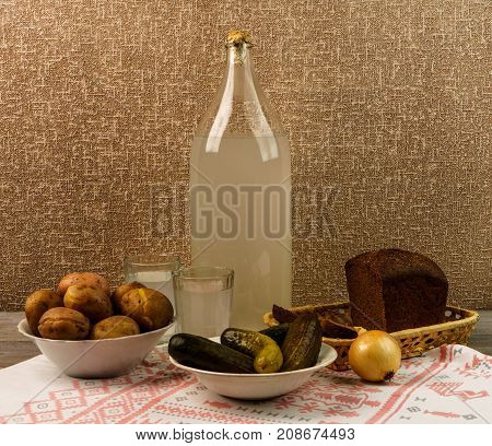 Ukrainian National Drink And Snack. The Big Bottle And Glass Of Moonshine On The Old Wooden Table