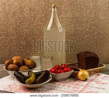 Ukrainian National Drink And Snack. The Big Bottle And Glass Of Moonshine On The Old Wooden Table