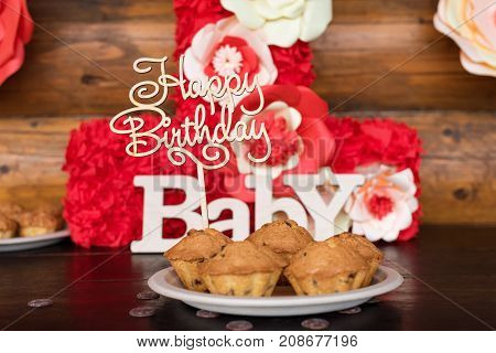 Birthday cakes, muffins with wooden greeting signs on rustic background. Wooden sing with letters Happy Birthday, Baby and holiday sweets
