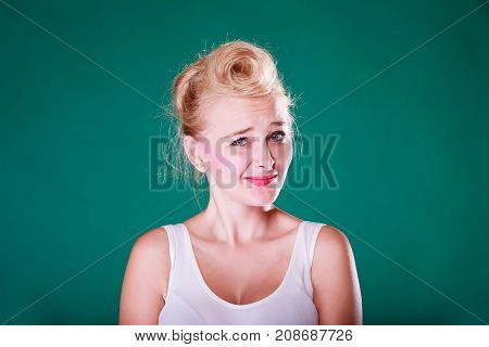Face expression emotions concept. Young woman with pin up hair being astonishment shocked and disgust. Studio shot on green background