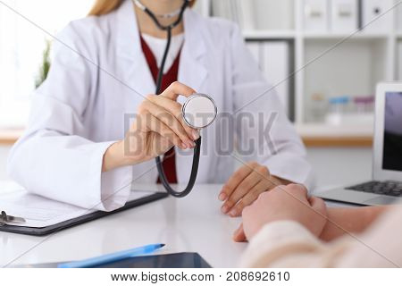 Unknown female doctor with a stethoscope in the hands. Physician is redy to exemine a patient. Medicine and health care conept
