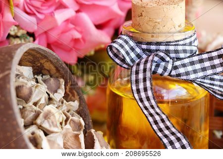Moringa oleifera oil and seeds on wood background