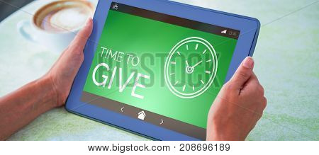 Time To Give text with clock icon on green screen against person holding tablet computer at table in cafe