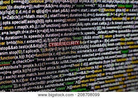 Macro photo of computer screen with program source code and highlighted CYBERSECURITY inscription in the middle. Computer script on the screen with virus in it. Cyber security concept.