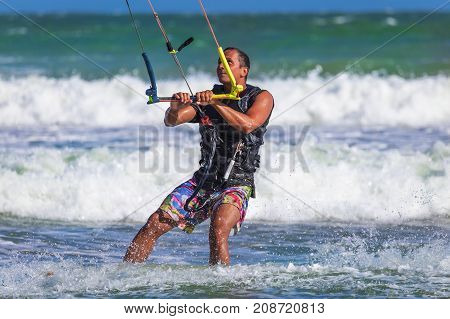 Young Atletic Man Riding Kite Surf On A Sea