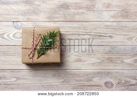 Gift box with red ribbon over white wooden background.
