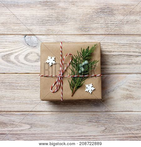 Gift box with red ribbon over white wooden background.