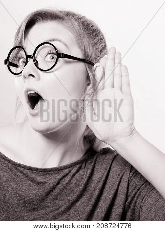Rumors and gossips concept. Newsmonger girl making listening gesture. Shocked surprised gossiping woman. Gossip and chatter.