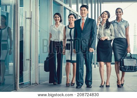 Asian business team of executives walking into office very determined to find some fault in the books they will do revision in 