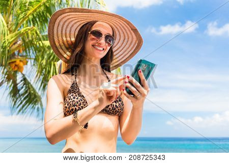 Tourist woman on vacation with smart phone on palm beach needs data roaming