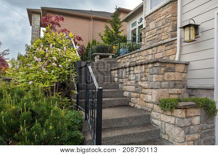 House frontyard cultured veneer stone work siding and rod iron stairs