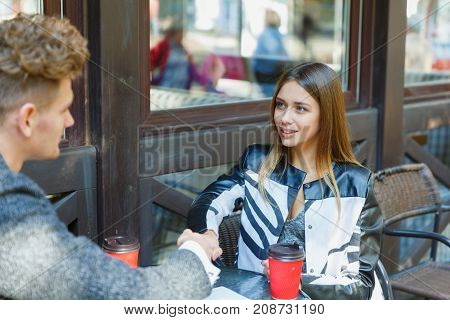 Two young business people using a digital tablet at a meeting in a cafe. With coffee. Close-up. The concept is business and finance.