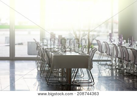 Indoor restaurant tables ready for service with a beautiful sunlught