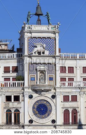 St Mark's Clock tower on Piazza San Marco Venice Italy. On the facade of the tower is the astronomical clock Lion of Saint Mark and Madonna with Child.At the top is a bell and Moors figures
