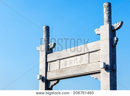 Suzhou, China - Nov 5, 2016: Closeup of stone gate in classical Chinese design named Wumen Impression (Chinese characters) on a public park, along the Waicheng River.