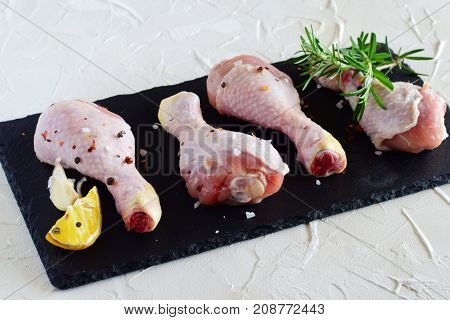 Raw Chicken Legs On A Black Slate