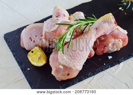 Raw Chicken Legs On A Black Slate