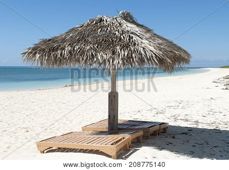 Straw umbrellas with chairs on Grand Bahama island Coral beach (Freeport Bahamas).