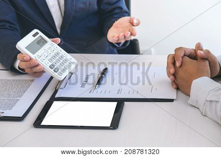 Businessman being analysis and making the decision a car insurance policy Agent man is using calculator to presentation detail and waiting for his reply to finish.
