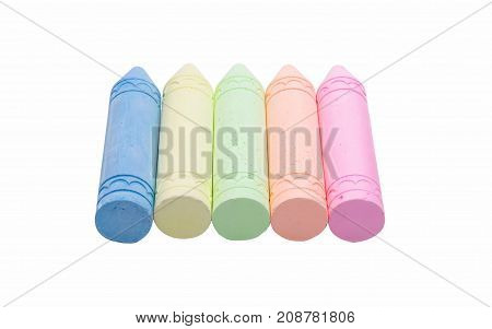 Sticks of pastel colored chalk casting shadow on white background.