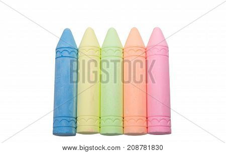 Sticks of pastel colored chalk casting shadow on white background.
