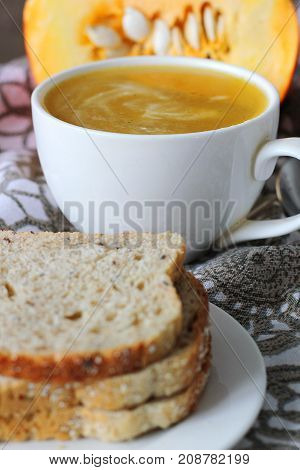 Pumpkin soup in white mug on table. Modern photography. The best for book with recipies.
