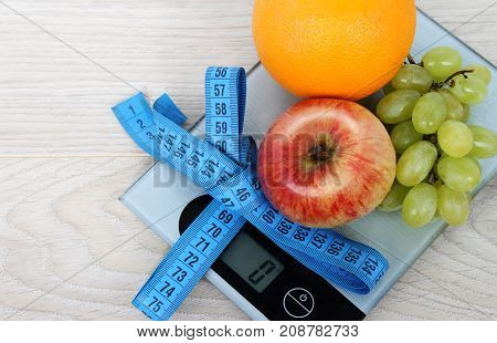 Fruits are apple orange grapes and meter on electronic scales. Diet.