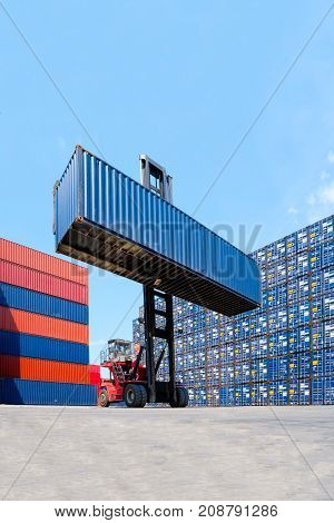 Forklift Truck Lifting Cargo Container In Shipping Yard Or Dock Yard With Cargo Container Stack In B