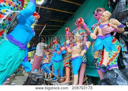 KUMARTULI KOLKATA INDIA - OCTOBER 10 2014 - Artist preparing clay idols of female demons to be used during Kali Puja worshipping of Goddess Kali Hindu festival of Deepavali or Diwali.