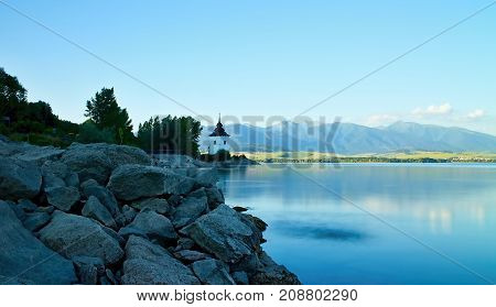 View on level water in dam Liptovska Mara with the background of the Havranok church. Water reservoir on Liptov.