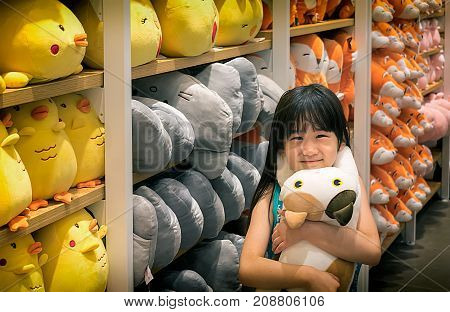 NONTHABURI THAILAND - OCTOBER 08: Japanese little girl Irisa Chujo hugs a Neko Atsume stuffed animal in MINIso gift shop located in CentralPlaza Westgate in Nonthaburi on October 06 2017.