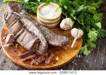 Beef Jerky Smoked Sausage Sudzhuk With Spices And Garlic Is Served On A Cutting Board.