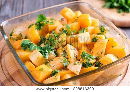 Baked pumpkin with aromatic herbs on the table