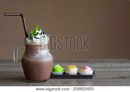 Iced coffee in glass and cookies fancy on wooden table