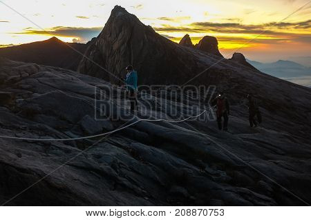 Mount Kinabalu,Ranau,Sabah.Malaysia-March 12,2016:Silhouette climber passing trail to the summit of Mountain Kinabalu during sunrise in Mount Kinabalu,Sabah,Malaysia.