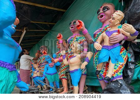 KUMARTULI KOLKATA INDIA - OCTOBER 10 2014 - Artist preparing clay idols of female demons to be used during Kali Puja worshipping of Goddess Kali Hindu festival of Deepavali or Diwali.