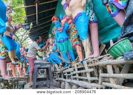 KUMARTULI KOLKATA INDIA - OCTOBER 10 2014 - Artist preparing clay idols of female demons to be used during Kali Puja worshipping of Goddess Kali Hindu festival of Deepavali or Diwali.