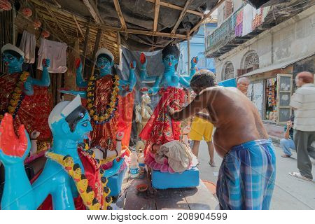 KUMARTULI KOLKATA INDIA - OCTOBER 10 2014 - Artist preparing clay idol to be worshipped as Goddess Kali during Kali Puja Hindu festival of Deepavali or Diwali. Celebtated all over India.