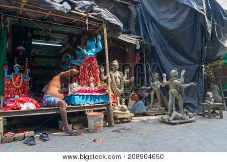 KUMARTULI KOLKATA INDIA - OCTOBER 10 2014 - Artist preparing clay idol to be worshipped as Goddess Kali during Kali Puja Hindu festival of Deepavali or Diwali. Celebtated all over India.