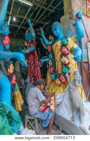 KUMARTULI KOLKATA INDIA - OCTOBER 10 2014 - Artist preparing clay idol to be worshipped as Goddess Kali during Kali Puja Hindu festival of Deepavali or Diwali. Celebtated all over India.
