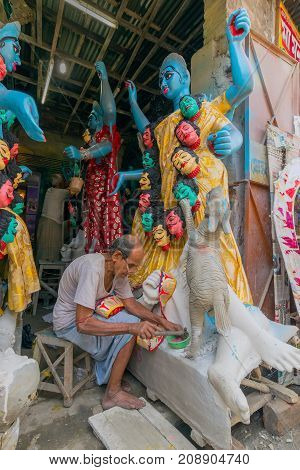 KUMARTULI KOLKATA INDIA - OCTOBER 10 2014 - Artist preparing clay idol to be worshipped as Goddess Kali during Kali Puja Hindu festival of Deepavali or Diwali. Celebtated all over India.