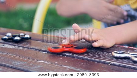 Close-up of a boy's hands playing with a spinner.