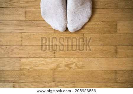 Foot with sock stand on wooden floor