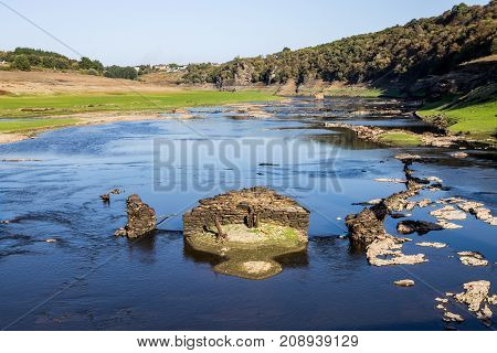 Stones and ruins on the bottom of a dry reservoir in Portomarin Northern Spain.