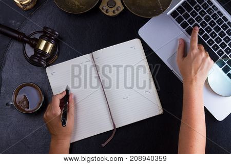 Workspace hero header with law gavel, legal book and laptop keyboard, hands typing and writting in notebook, top view flatlay scene