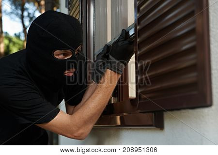Robbery or burglary. break-in of an apartment. Thief in mask